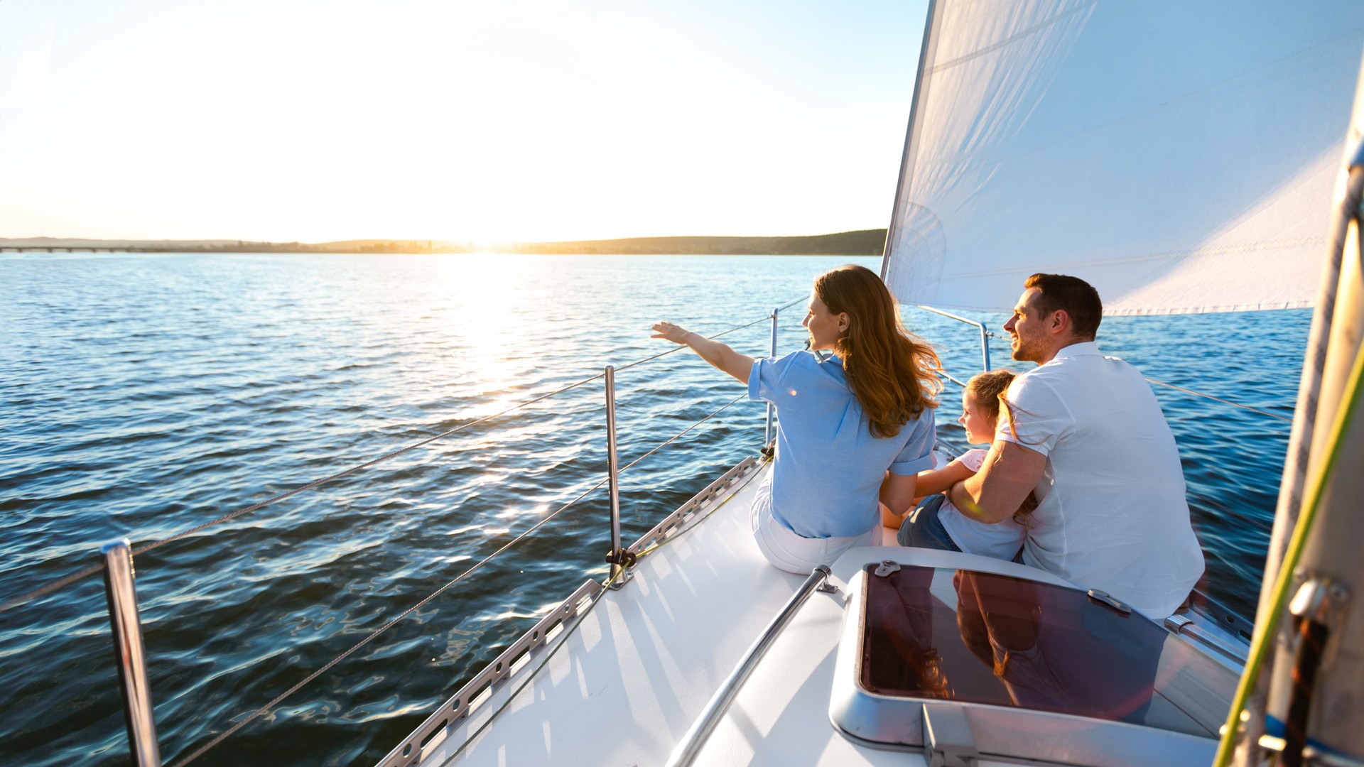 Family Sitting On Yacht Deck Sailing Across The Sea